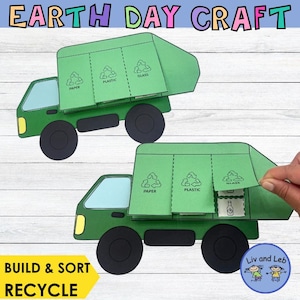 May include: Two green paper craft recycling trucks with black wheels. The trucks have compartments labeled "Paper", "Plastic", and "Glass". The text "Earth Day Craft", "Build & Sort", and "Recycle" are also visible.