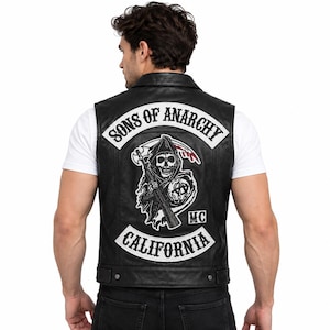 May include: A black leather vest featuring a large back patch with the text SONS OF ANARCHY in a white arched banner, a central graphic of a grim reaper holding a rifle and a scythe, and a bottom banner with the text CALIFORNIA and MC.