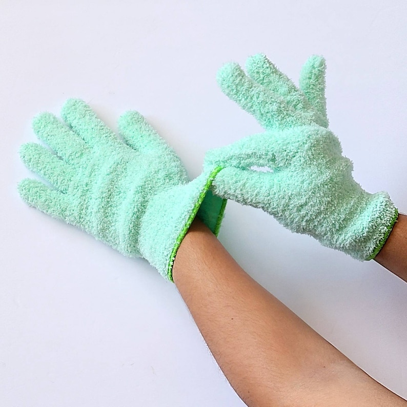 May include: A pair of light green microfiber cleaning gloves with a green trim. The gloves are made of a soft, absorbent material and are perfect for cleaning delicate surfaces.