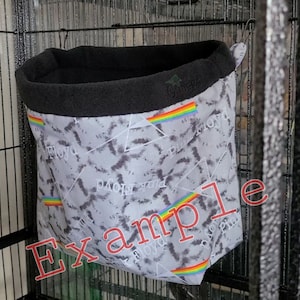 May include: A gray and black hanging bird hammock with a rainbow stripe and the text "Pink Floyd" repeated on the fabric.