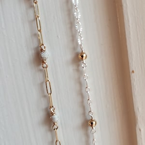 Puede incluir: Dos delicados collares con cadenas de oro y plata y peque&ntilde;as cuentas redondas. La cadena de oro tiene cuentas texturizadas y la cadena de plata tiene cuentas lisas.