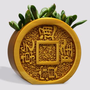 May include: A gold-colored, round, wooden planter shaped like a Chinese coin with Chinese characters. The planter is filled with green succulent plants.