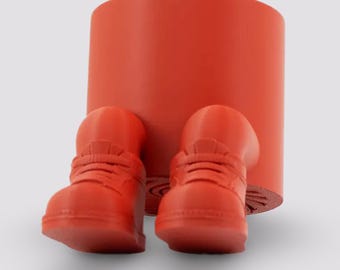 May include: Orange ceramic planter shaped like a person with legs in the form of sneakers. The planter is sitting on a white surface.