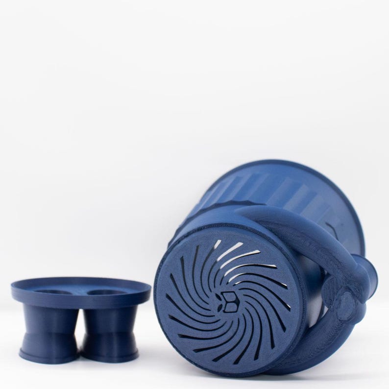 May include: A blue plastic planter with a unique design and a separate blue plastic base with two holes. The planter has a swirl pattern and a handle.