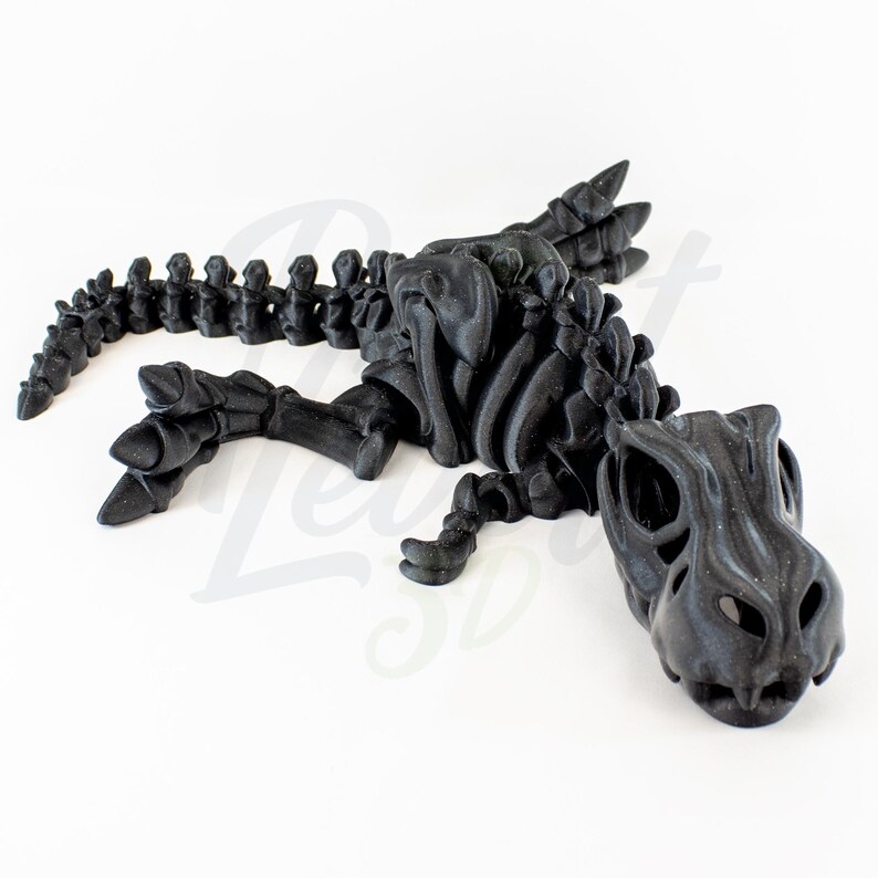 May include: A black 3D printed dinosaur skeleton model. The dinosaur is lying on its side with its head turned to the side. The skeleton is detailed and realistic.