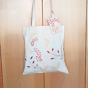 Kit Canvas-Einkaufstasche und handbemalte Geldbörse mit langen Henkeln zum Aufhängen an der Schulter. Ökologisch und biologisch