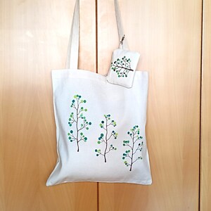 Set aus umweltfreundlicher und veganer Canvas-Tragetasche und handbemalter Geldbörse mit langen Henkeln.