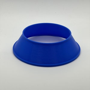 May include: A blue plastic ring with a wide base, designed to hold a variety of items.