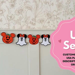 May include: A Halloween banner with pumpkin and ghost-shaped decorations, featuring Mickey and Minnie Mouse. The banner is set against a floral wallpaper. A pink sign with the text "UK Seller" is also visible in the image.