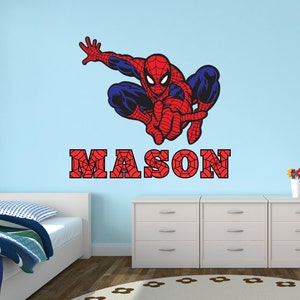 Puede incluir: Un adhesivo de pared de Spiderman rojo y azul con un dise&ntilde;o de telara&ntilde;a. El nombre "MASON" est&aacute; escrito en rojo con un dise&ntilde;o de telara&ntilde;a.
