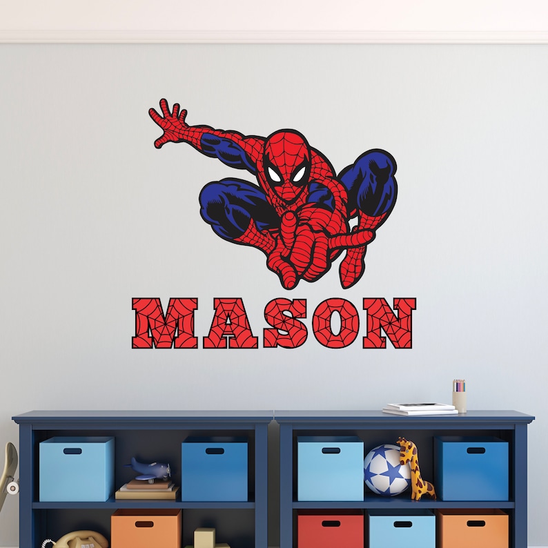 Puede incluir: Un adhesivo de pared Spiderman rojo y azul con un dise&ntilde;o de telara&ntilde;a. El nombre "MASON" est&aacute; escrito en rojo con un dise&ntilde;o de telara&ntilde;a.