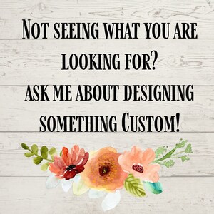 May include: A wooden sign with a white background and black text that reads "Not seeing what you are looking for? Ask me about designing something custom!" The sign is decorated with a floral arrangement of peach, red, and green flowers.