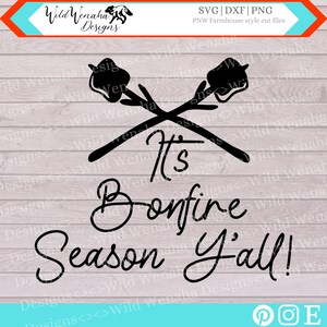 Puede incluir: Diseño gráfico en blanco y negro con palos cruzados y malvaviscos, con el texto "It's Bonfire Season Y'all!"