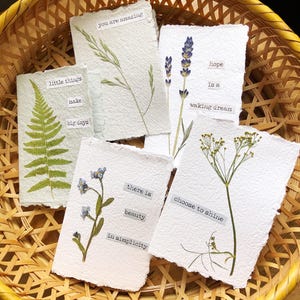 vraies fleurs pressées sur du papier fait main avec des messages positifs