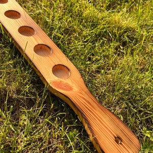 Pu&ograve; includere: Un porta bicchieri da shot in legno con sei incavi rotondi per contenere i bicchieri da shot. Il porta bicchieri &egrave; in legno naturale con una finitura rustica e un manico.