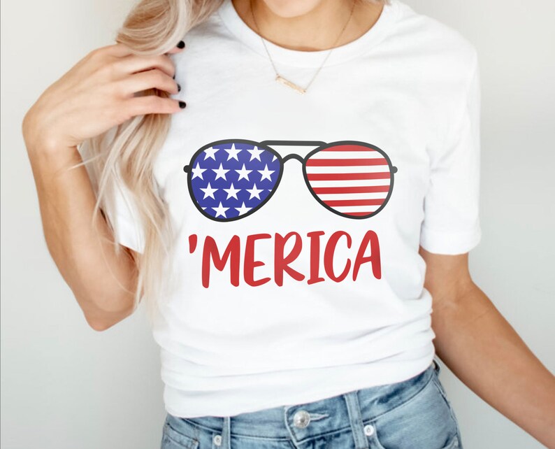 May include: White t-shirt with a graphic of sunglasses with an American flag design and the text 'MERICA' in red.