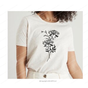 May include: A white t-shirt with a black line drawing of a bouquet of flowers. The flowers are stylized and have a simple, minimalist design.