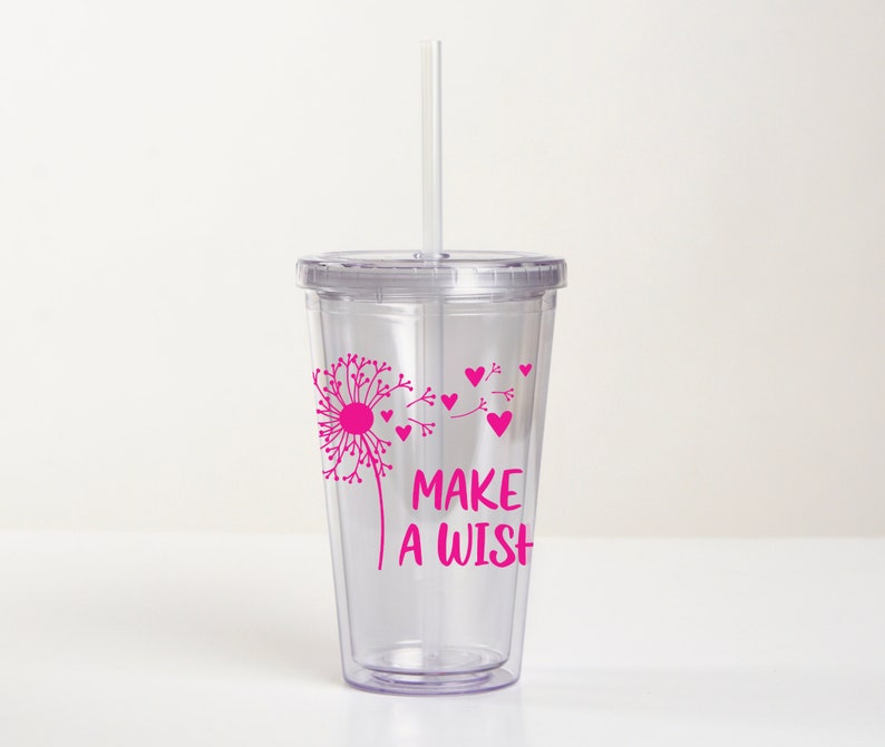 May include: Clear plastic tumbler with a pink dandelion design and the text "Make a Wish". The tumbler has a lid and a straw.