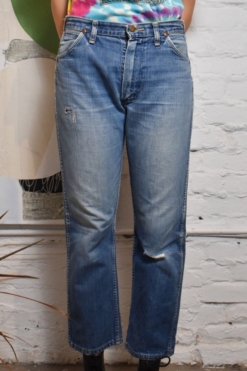 K&ouml;nnte beinhalten: Eine hellblaue Jeanshose mit Used-Look. Die Jeans hat einen geraden Schnitt und eine mittelhohe Taille.