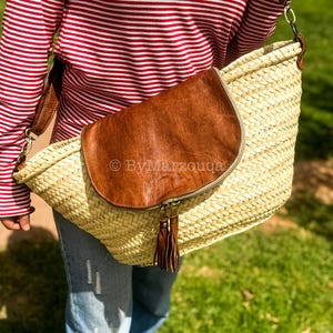 Handmade straw basket bag with genuine leather flap and adjustable strap. Spacious, lined, and perfect for everyday use or summer outings.