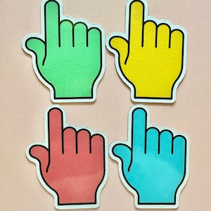 May include: Four colorful pointing hand stickers. The stickers are green, yellow, red, and blue. Each sticker has a black outline.