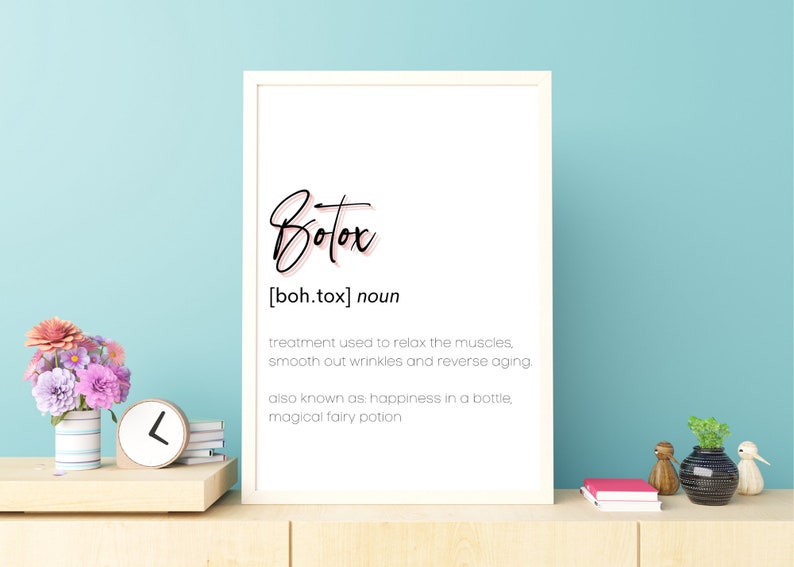 May include: A white framed print with the word "Botox" in black script with a pink outline. The definition of Botox is written below in black text: "[boh.tox] noun treatment used to relax the muscles, smooth out wrinkles and reverse aging. also known as: happiness in a bottle, magical fairy potion"