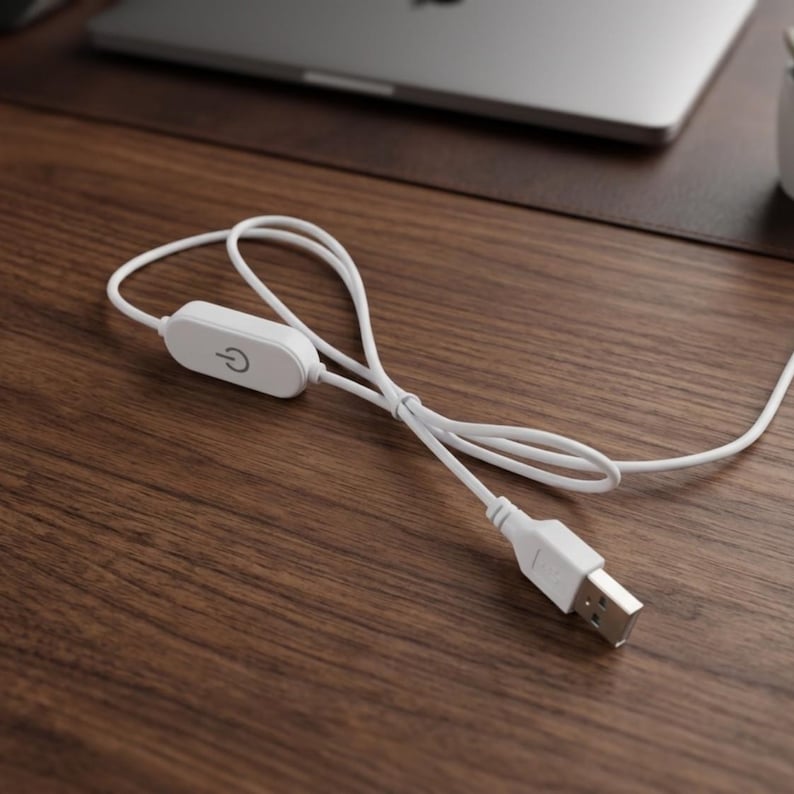 Puede incluir: Un cable de alimentaci&oacute;n USB blanco con un interruptor de control integrado en l&iacute;nea. La carcasa rectangular del interruptor muestra un icono de s&iacute;mbolo de encendido gris. El cable tiene un conector USB-A est&aacute;ndar y un cord&oacute;n blanco flexible.