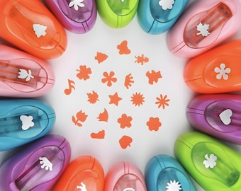 May include: A set of 12 colorful paper punchers with different shapes, including a heart, star, flower, and leaf. The punchers are arranged in a circle around a white surface with small paper cutouts of the shapes.