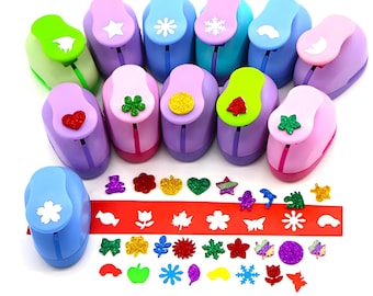 May include: A set of 12 colorful paper punchers with different shapes, including stars, snowflakes, hearts, and leaves. The punchers are arranged in a semi-circle with a row of punched out shapes below them.