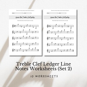 Op de afbeelding: Twee witte werkbladen met muzieknotatie en de tekst "Name the Treble Clef Notes". De werkbladen maken deel uit van een set "Treble Clef Ledger Line Notes Worksheets (Set 2)" met 10 werkbladen.