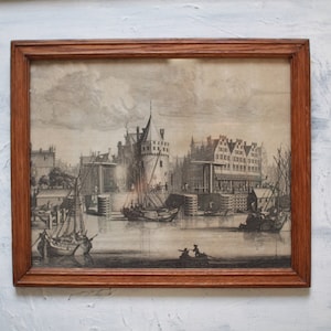May include: A framed black and white print depicting a harbor scene with multiple ships and buildings. The print is in a wooden frame with a brown finish.