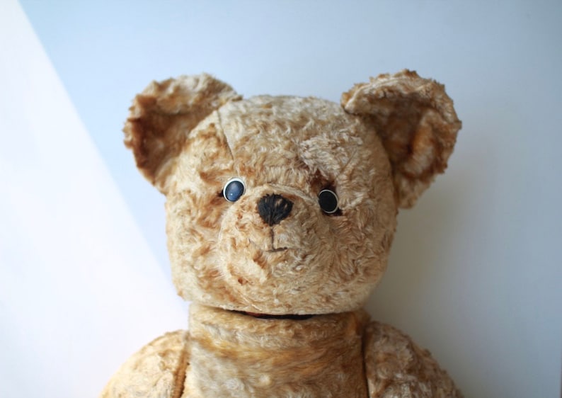 Peut inclure: Un ours en peluche vintage &agrave; la fourrure brune et aux yeux noirs en boutons. L'ours a un aspect us&eacute; et d&eacute;lav&eacute;, ce qui sugg&egrave;re qu'il est antique.