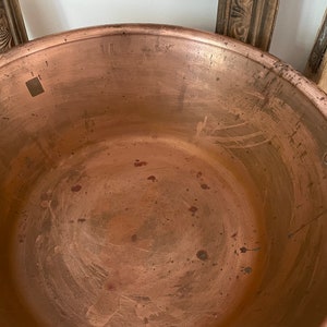 Puede incluir: Una olla grande de cobre con una p&aacute;tina desgastada y envejecida. El interior de la olla es liso y muestra signos de uso. La olla tiene una abertura redonda ancha y un borde ligeramente acampanado.