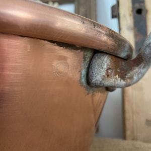 Puede incluir: Una olla grande de cobre con asa y una marca del fabricante que dice "FABRIQUE EN FRANCE".