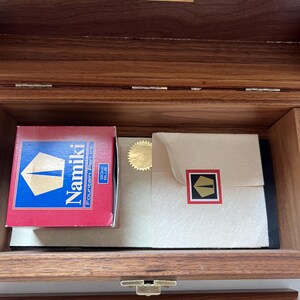 May include: A wooden box with a brass clasp, containing a red and blue Namiki fountain pen ink box, a cream-colored envelope with a gold seal, and a gold plaque that reads "Limited Edition White Tiger Fountain Pen 191/300."