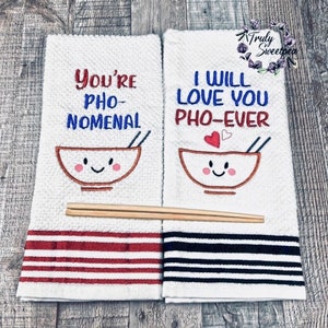 May include: Two white kitchen towels with red and black stripes. The towels have embroidered text and a cartoon bowl of noodles. The text on the towels reads "You're Pho-Nomenal" and "I Will Love You Pho-Ever".