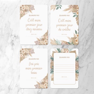 May include: Four printable cards with a neutral color scheme featuring illustrations of pampas grass and other foliage. The cards have the text 'AUJOURD'HUI' and various French phrases including 'C'est mon premier jour chez nounou', 'C'est mon premier jour de crèche', 'J'ai pris mon premier bain', and a blank space for writing. The cards are designed for recording special moments in a baby's life.