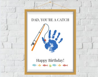 Könnte beinhalten: Eine weiße, druckbare Karte mit einem blauen Handabdruck und einer Angelrute mit einem roten Schwimmer. Der Text auf der Karte lautet "Papa, du bist ein Fang" und "Alles Gute zum Geburtstag!" mit einer Reihe bunter Fische am unteren Rand.