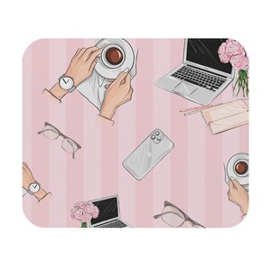 Puede incluir: Una alfombrilla de ratón rectangular con un patrón repetitivo sobre un fondo de rayas rosa claro. El diseño incluye ilustraciones de ordenadores portátiles, teléfonos inteligentes, gafas, tazas de café y ramos de flores rosas.