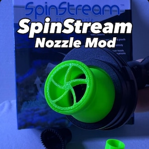 May include: A close-up of a green and black SpinStream Nozzle Mod. The nozzle has a bright green, fan-like design. Additional green and black components are also visible. The product is designed for wave patterns, growth, and electricity.