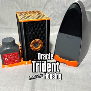 Peut inclure: Bo&icirc;tier empilable Oracle Trident noir et orange avec un motif en nid d'abeille. Le bo&icirc;tier pr&eacute;sente un accent orange circulaire. Une bouteille grise avec du texte rouge et blanc et un appareil gris et orange sont &eacute;galement dans l'image.