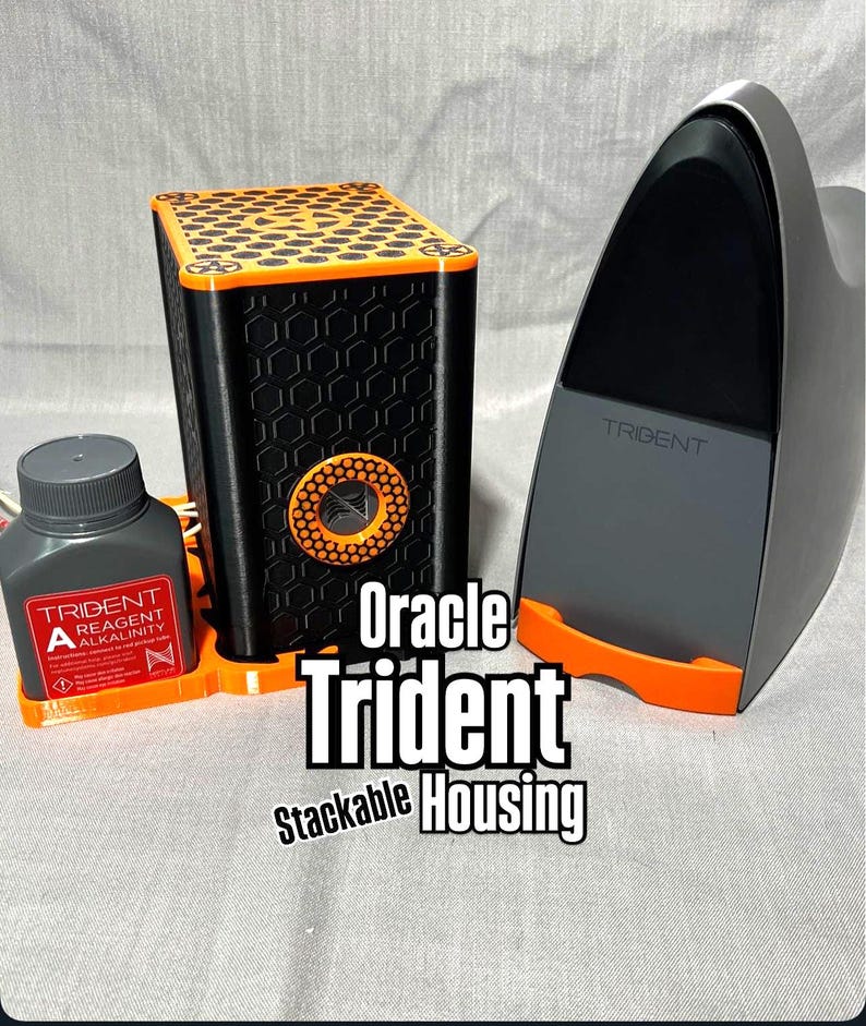 Peut inclure: Bo&icirc;tier empilable Oracle Trident noir et orange avec un motif en nid d'abeille. Le bo&icirc;tier pr&eacute;sente un accent orange circulaire. Une bouteille grise avec du texte rouge et blanc et un appareil gris et orange sont &eacute;galement dans l'image.