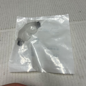 Puede incluir: Una cánula nasal de plástico transparente con un conector gris. La cánula está empaquetada en una bolsa de plástico transparente con el texto "ResMed AirFit P10 Nasal Mask" impreso en la bolsa.