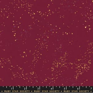 May include: A deep red fabric with a scattered gold glitter pattern. The fabric is a solid color with a subtle texture.