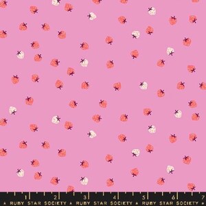 May include: Pink fabric with a repeating pattern of strawberries. The strawberries are in shades of red and white, with green stems. The fabric has a bright pink background. The text "RUBY STAR SOCIETY" is printed along the bottom.