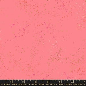 May include: Pink fabric with a speckled pattern of gold and pink dots. The fabric has a subtle sheen and a soft texture.