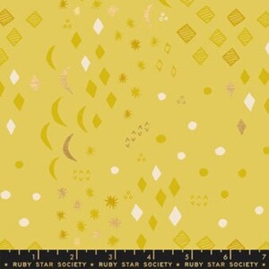 May include: A yellow fabric with a repeating pattern of gold and white geometric shapes, including diamonds, crescents, stars, and circles. The fabric is from Ruby Star Society.