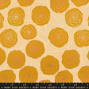 May include: A fabric with a repeating pattern of yellow flowers on a light peach background. The flowers have a pink center and are outlined in a darker yellow. The background has a subtle striped pattern.