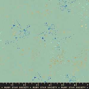 May include: A fabric with a light green background and a scattered pattern of blue, gold, and white paint splatters. The fabric has a ruler along the bottom with the text "RUBY STAR SOCIETY".