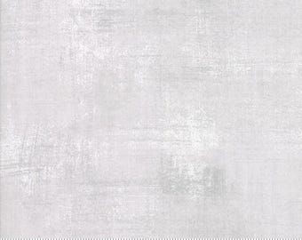Könnte beinhalten: Nahaufnahme eines hellgrauen Stoffes mit einem dezenten, strukturierten Muster. Der Stoff hat einen leicht abgenutzten Look mit einem Hauch von Weiß durchgehend. Der Stoff ist mit einem Lineal gekennzeichnet, das die Maße in Zoll anzeigt.